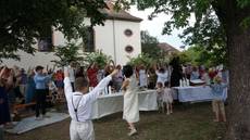 Singende Gemeinde im Garten beim Bewegungslied, Arme erhoben