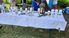 Biertisch mit weißem Tischtuch. Darauf viele Taufkerzen.