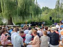 große Menschenmenge auf der Neckarwiese beim Tauffest am Neckar, Blick über die Gottesdienstbesucher zur sitzenden Reihe aus  Pfarrpersonen und Diakon